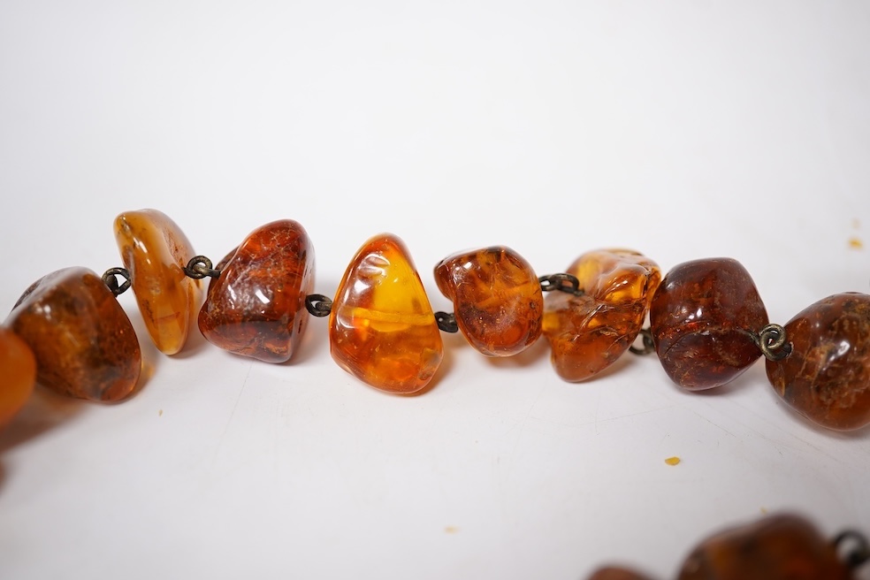 Three assorted amber necklaces including a single strand graduated oval bead necklace, 40cm, gross weight 37 grams, the other two necklaces gross weight 240 grams. Condition - poor to fair